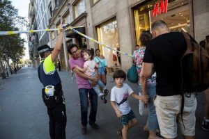 A police officer helps evacuate people after a van crashed into pedestrians near the Las Ramblas avenue in central Barcelona, Spain August 17, 2017. Ana Jimenez/La Vanguardia/via REUTERS