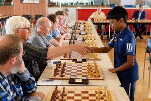 During a strong grandmaster chess tournament two weeks ago in Vlissingen, Netherlands, 12-year-old Indian International Master R Praggnanandhaa (right) played a 20-board clock simultaneous exhibition against some recognized Dutch chess players. ‘Pragg’ as he is called, won the encounter 20-0. Clock simultaneous exhibitions are more taxing than those without since one has to keep moving and maintain the quality of one’s moves. In photo: Pragg exchanges the traditional handshake prior to the beginning of his encounter. (PhotoChess News/Ploegarts)