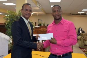 President of the AAG, Aubrey Hutson is all smiles as he received the sponsorship cheque
yesterday from Courts (Unicomer Guyana Inc.) Marketing Manager, Pernell Cummings. 