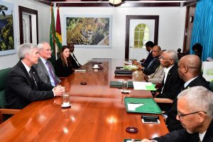President David Granger makes a point to Darren Woods (second from left on left side of table), Chairman and Chief Executive Officer of ExxonMobil as officials of the Government and ExxonMobil look on.  (Ministry of the Presidency photo)