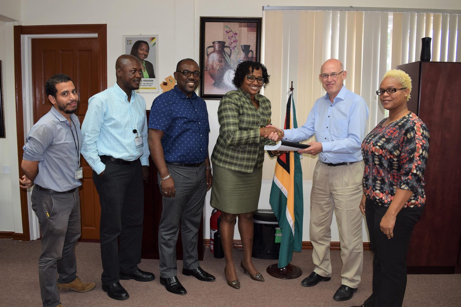 Minister within the Ministry of Public Infrastructure, Annette Ferguson (third from right) receives the completed Feasibility Study and Design for the new Demerara River Bridge from Ariel Mol of LievenseCSO. With them are the members of the project team: DHBC General Manager and Project Manager, Rawlston Adams (third, left); Chief Transport and Planning Officer at MPI, Patrick Thompson (second, left); Senior Engineer (Transport and Planning), Ronald Roberts (left); and Transport Planning Officer (Economist) Ramona Duncan (MPI photo) 