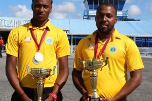 Skipper Ronaldo Ali - Mohammed (left) and Coach Julian Moore (right) with the silverware yesterday (Royston Alkins Photo) 
