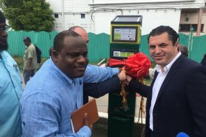 From left: Town Clerk Royston King, SCS Global Head of Operations Simon Mosheshvili (partly hidden) and Smart City Solutions Global Head of Business Development Amir Oren cutting the ribbon on the first parking meter outside City Hall on Regent Street on December 21, 2016.