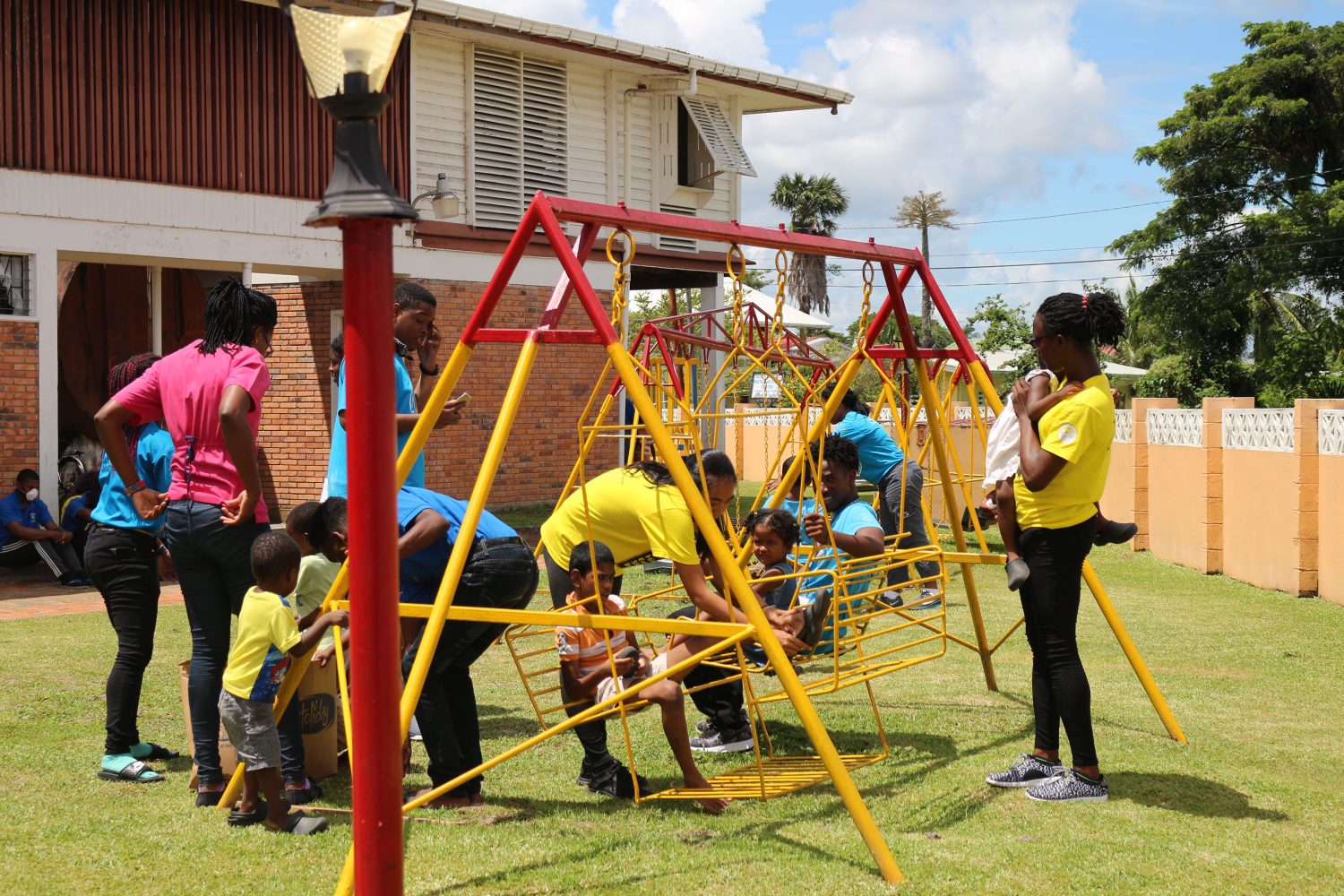 Some of the Caribbean Award Sub-Regional Council (CASC) participants pushing children on a swing (DPI photo)
