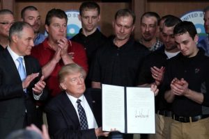 In the company of coal miners, U.S. President Donald Trump signs an executive order eliminating Obama-era climate change regulations at the Environmental Protection Agency in Washington. (Carlos Barria/Reuters)