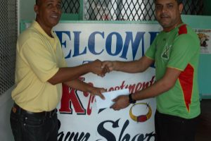 Managing Director of YK Investments & Pawn Shop Marlon Yenkana (right) hands over the sponsorship cheque to Three Peat Promotions representative Rawle Welch.