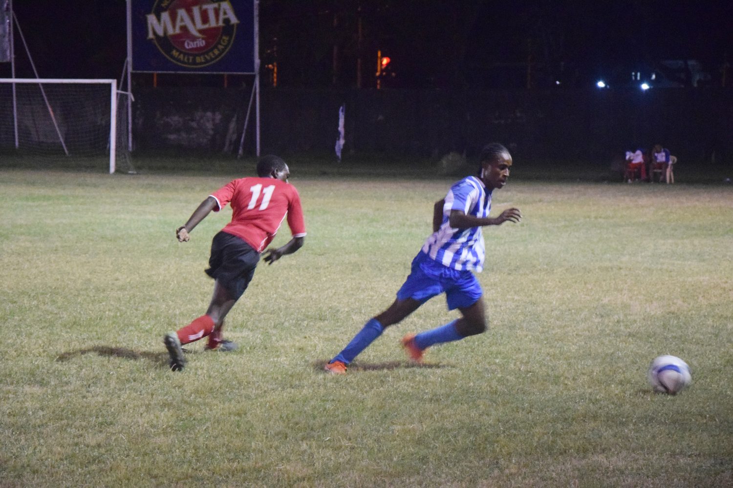 Teon Jones (left) of Riddim Squad in hot pursuit of a GFC during their quarterfinal showdown in the Corona Beer Invitational Football Championship.