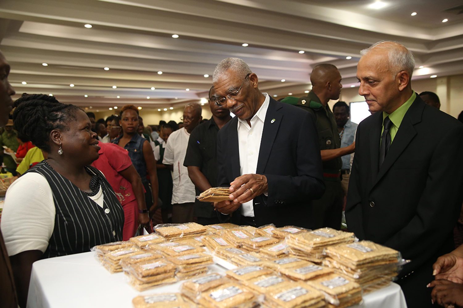 President David Granger (at centre) along with Minister of Communities Ronald Bulkan viewing the display of coconut biscuits at the launch of the Regional Agricultural and Commercial Exhibition (RACE) yesterday.
