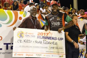 Chris Gayle (R) of St Kitts & Nevis Patriots receives the runners-up cheque from Most Hon. PJ Patterson (L) of CPL after the Finals of the 2017 Hero Caribbean Premier League between Trinbago Knight Riders and St Kitts & Nevis Patriots at Brian Lara Cricket Academy in Tarouba, Trinidad. (Photo by Randy Brooks - CPL T20 via Getty Images)
