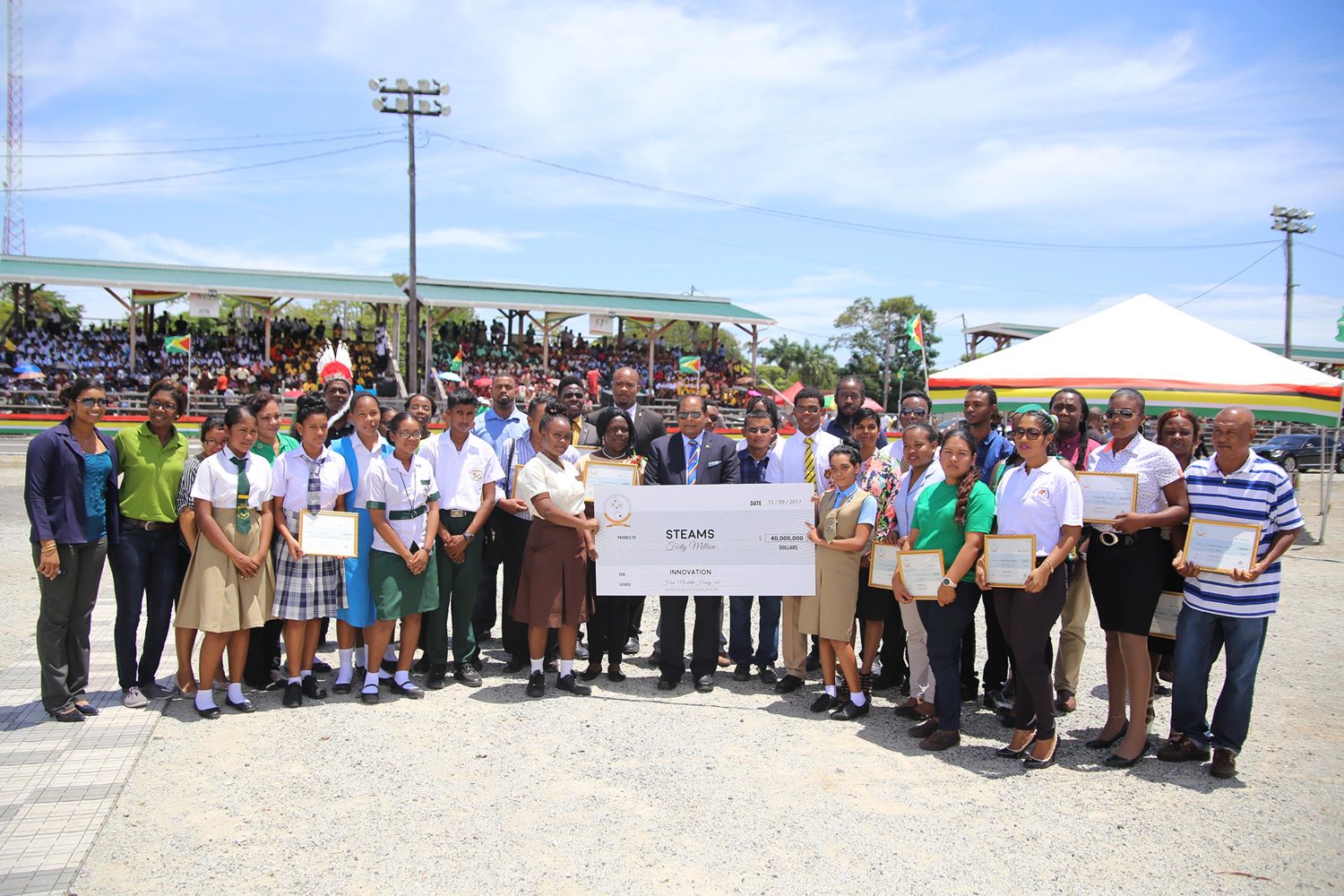 24 groups and 13 Science Technology Engineering and Mathematics (STEM) clubs were awarded $40 million in cash grants through the Innovation Programme of Guyana. Here, Prime Minister Moses Nagamootoo (at centre with cheque) stands with some of the awardees. (Photo by Keno George)