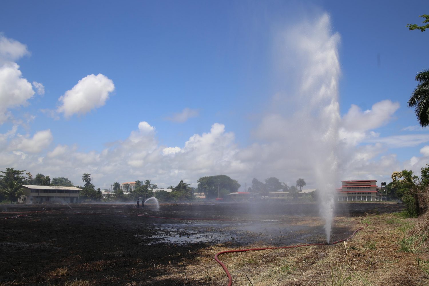 A leak sprung from the hose as firefighters worked to douse the Queen’s College field after flames had engulfed it early yesterday morning. See story on page 17. (Photo by Keno George) 