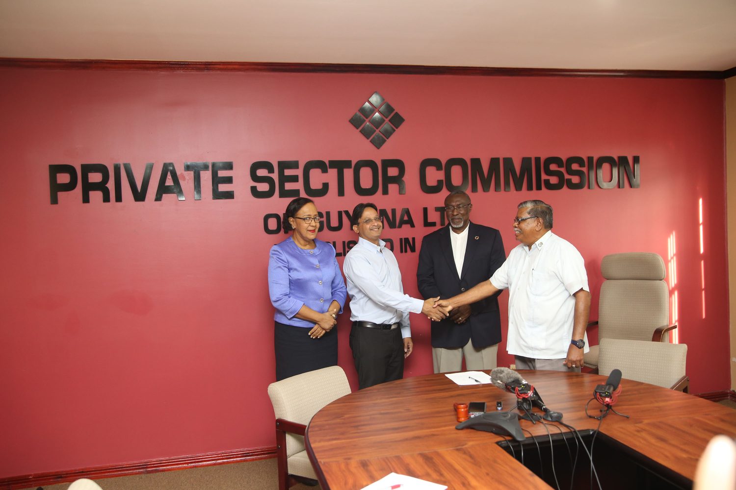 A ceremonial handshake between the Director General of the Civil Defence Commission Chabilall Ramsarup (far right) and the Chairman of the Beharry Group of Companies Edward Anand Beharry at the handing over of donations for the victims of Hurricanes Irma and Maria yesterday. Also photographed are Elizabeth Alleyne (far left), Executive Director of the Private Sector Commission (PSC), and Desmond Sears, Vice-Chairman of the PSC. (Photo by Keno George)
