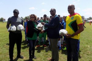 Minister within the ministry of Indigenous Affairs Valarie Garrido-Lowe receives the donation of footballs from Guyana Football Federation president Wayne Forde. 