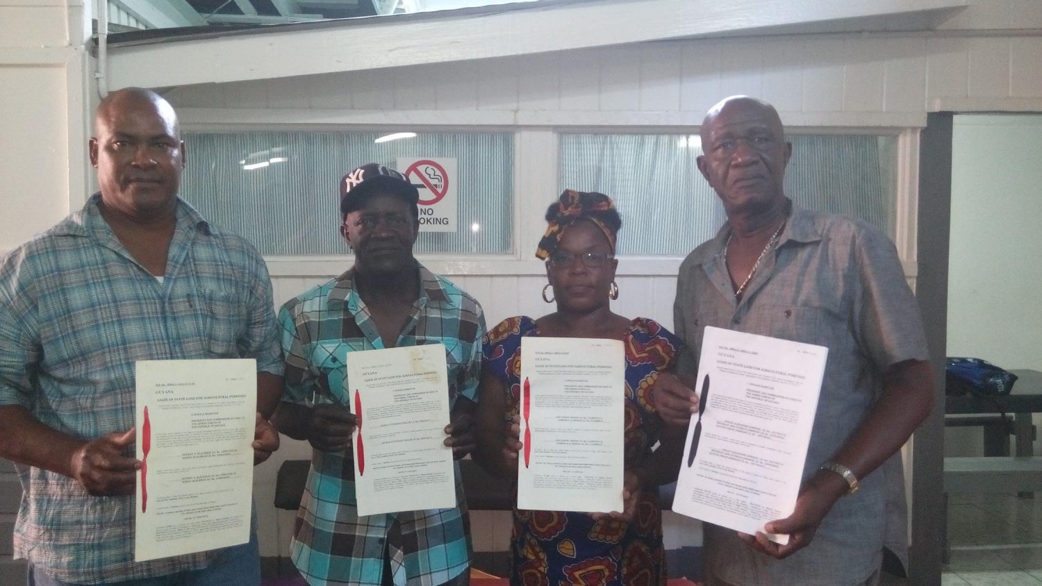 Revoked leases: Rice farmers (from left) Rawle Miller, Rupert Blackman, Doreen Monah and Philip Alexander Johnson holding up their leases last week.