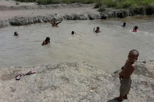 Persons cooling off in a canal in the village
