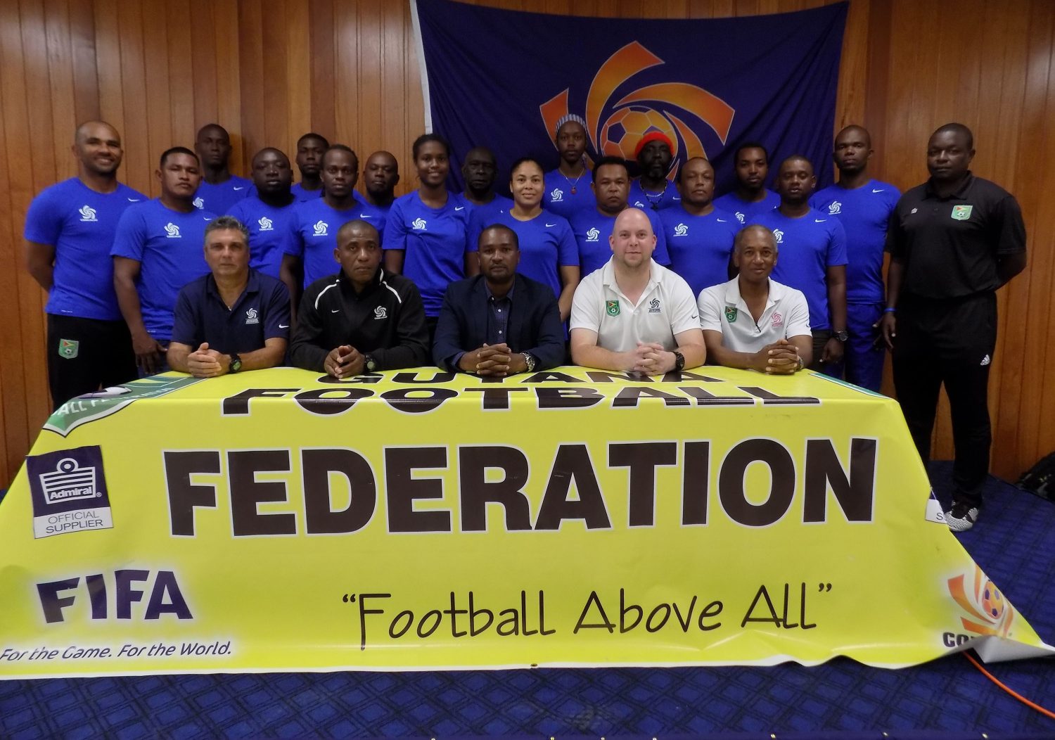 CONCACAF Instructors Juan Carlos Michia ( left) and Lenny Lake (2nd left), GFF President Wayne Forde (centre), GFF Technical Director Ian Greenwood (2nd right), Executive Committee member Keith O’Jeer (right) and the participating coaches (standing) following the launch of the CONCACAF D-Licence Programme  
 

