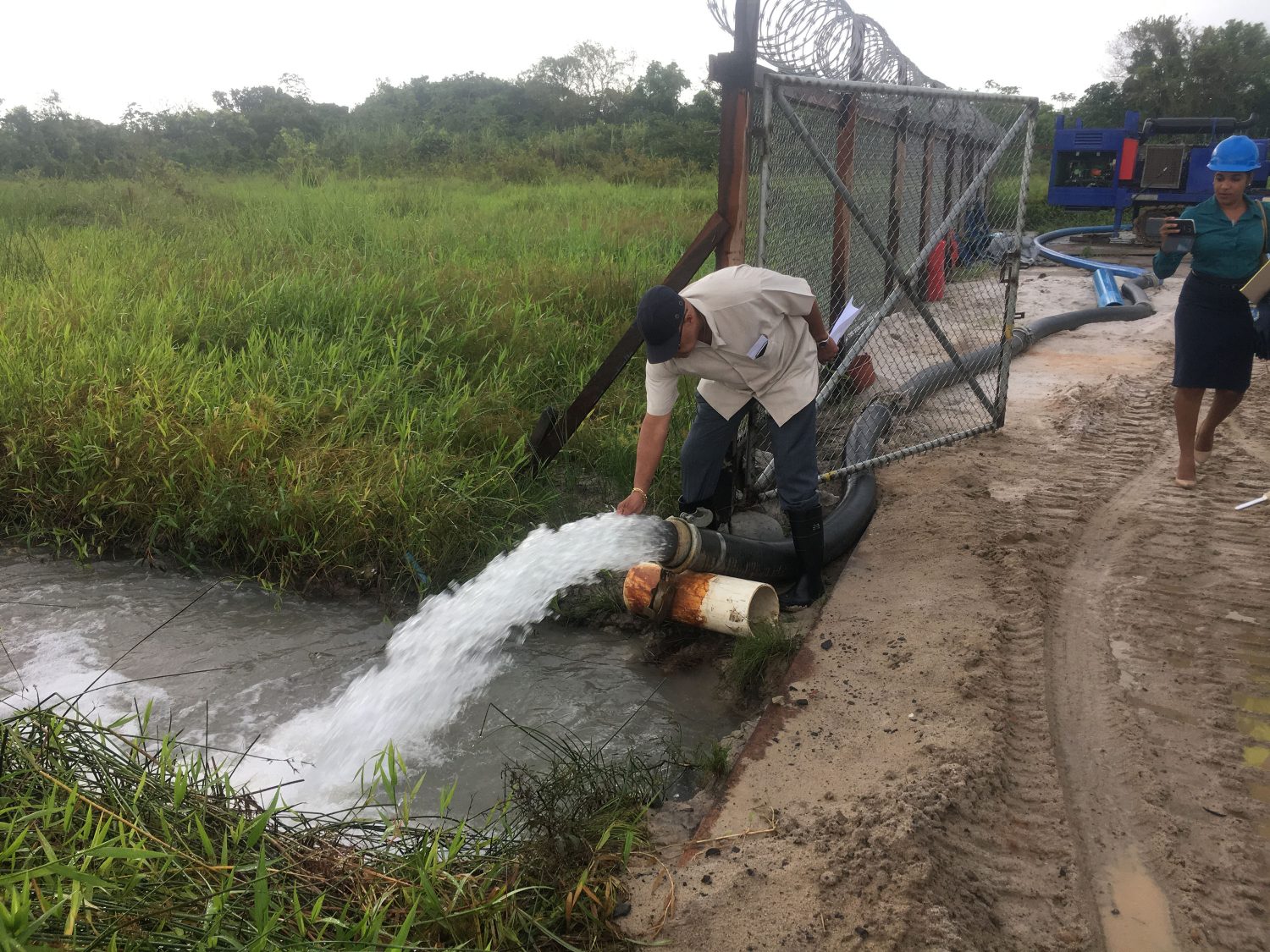 CEO of GWI Dr. Richard Van West-Charles checking the quality of water from the recently dug well at Diamond, East Bank Demerara (Dhanash Ramroop photo) 