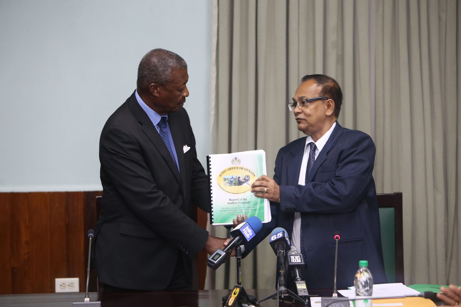 Auditor General Deodat Sharma (right) hands over the 2016 Audit Report to Speaker of the National Assembly Barton Scotland.