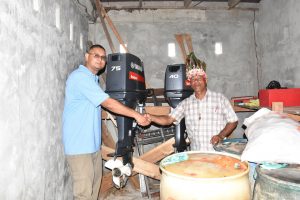 Project Manager of the Amerindian Development Fund Omar Bispat (left) with Chairman of the Dog Point Community Development Council Thomas John. Behind are the engines that have been acquired for the boats. 