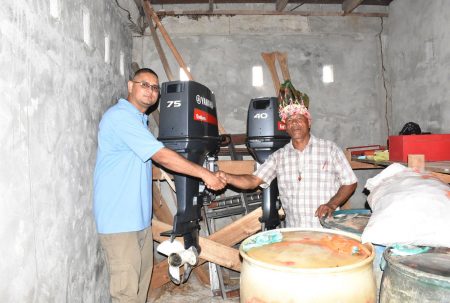 Project Manager of the Amerindian Development Fund Omar Bispat (left) with Chairman of the Dog Point Community Development Council Thomas John. Behind are the engines that have been acquired for the boats. 