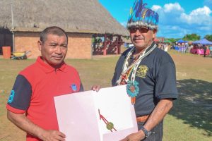 Minister of Indigenous Peoples’ Affairs, Sydney Allicock (right) presenting the document to Aishalton’s Toshao, Douglas Casimero (DPI photo)