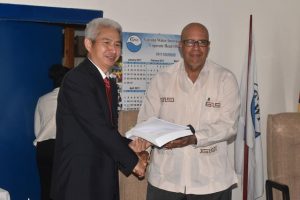 Managing Director of GWI Dr. Richard Van West-Charles (right) and Project Manager of Siohydro, Hong Zhou shake hands on the contract for the water treatment plants (DPI photo)