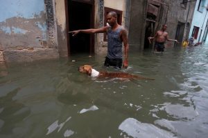 A man gestures to his dog on a flooded street, after the passing of Hurricane Irma, in Havana, Cuba September 10, 2017. REUTERS/Stringer