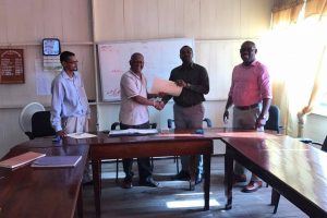 Guyana Football Federation (GFF) president Wayne Forde, second from right, receives the signed Memorandum of Understanding from Eccles/Ramsburg NDC chairman Mahamad Hafeez. (Photo courtesy of the GFF)