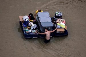 Residents wade with their belongings through flood waters brought by Tropical Storm Harvey in Northwest Houston, Texas, U.S. August 30, 2017. REUTERS/Adrees Latif