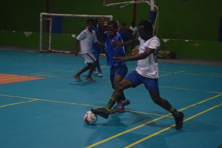 Benjamin Opara (blue) of the African Team attempting to win possession from an Old School Ballers player during their clash at the National Gymnasium in the inaugural Futsal Nation Cup
