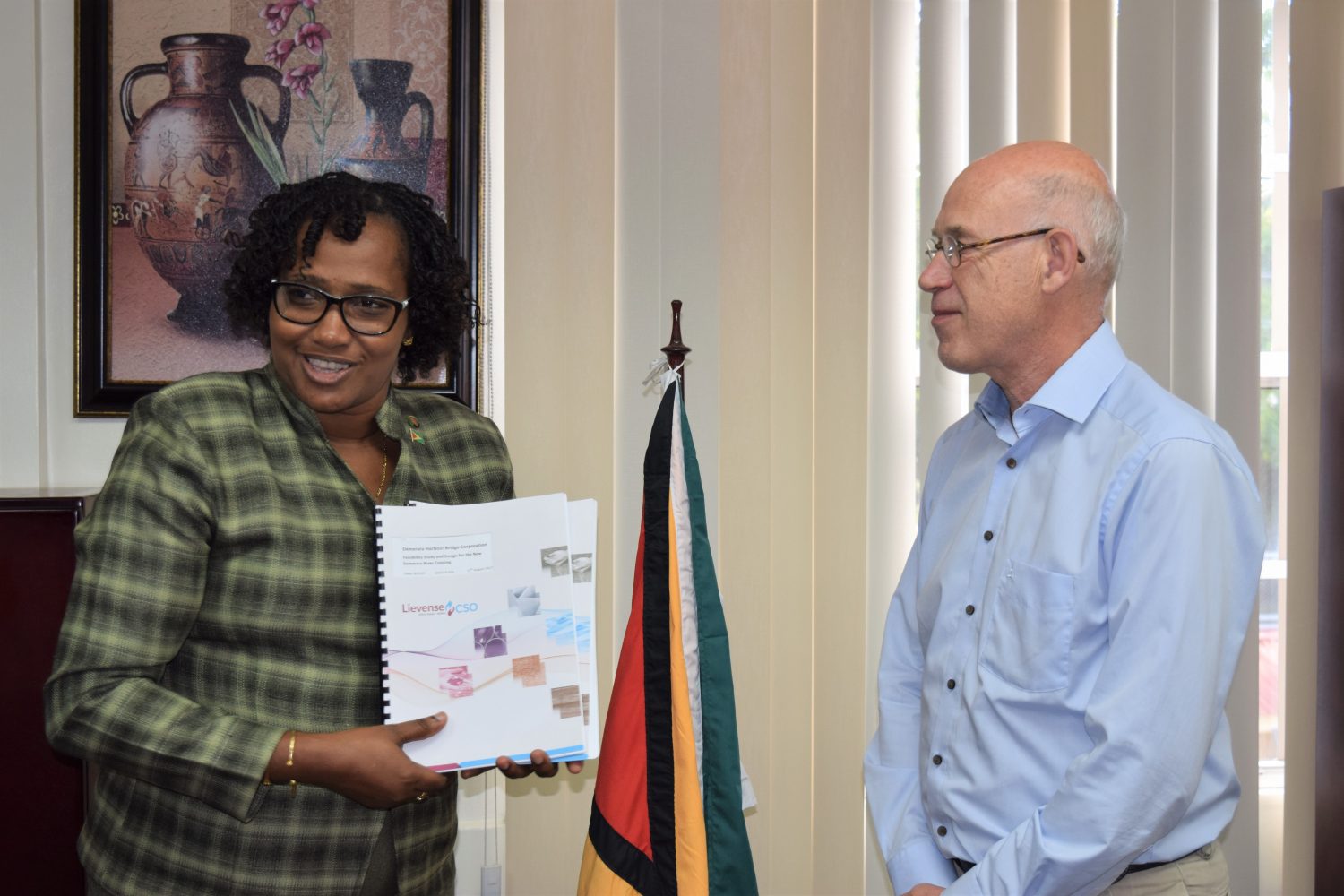 Minister within the Ministry of Public Infrastructure, Annette Ferguson (left) and  Ariel Mol of LievenseCSO following the handing over of the completed Feasibility Study and Design for the new Demerara River Bridge on August 30, 2017.