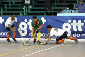 Jason DeSantos (center) of the National Green hockey team, skips past the challenges from the Bounty GCC duo of Mark Sargeant (left) and Samuel Woodroffe during their men’s first division clash in the GTT National Indoor Championships Thursday at the Cliff Anderson Sports Hall.
