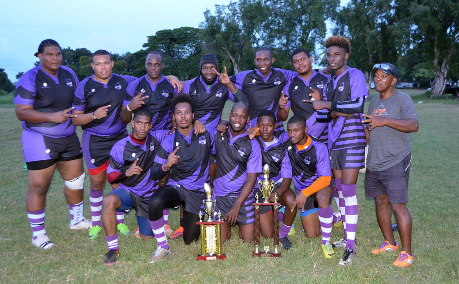 Back-to-back! The Panthers Rugby Club pose with their winning trophies yesterday. (Orlando Charles photo)