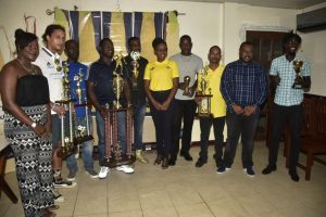 Representatives of the top four finishers in the recently concluded Corona Invitational Football Championship displaying their spoils in the presence of members of the tournament sponsor Top Brandz and event coordinator,  the Petra Organization at the Brandsville Hotel. 