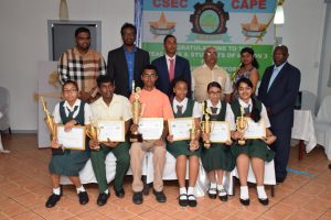 Standing  (left to right) are MP Mohamed Irfan Alli, Region Three, Chamber of Industry and Commerce (R3CCI) President Radesh Rameshwar and other officials. The awarded students are seated. (DPI photo)