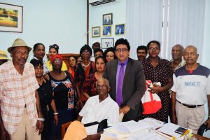 Some of the affected villagers with their attorney Anil Nandlall (fifth from right).