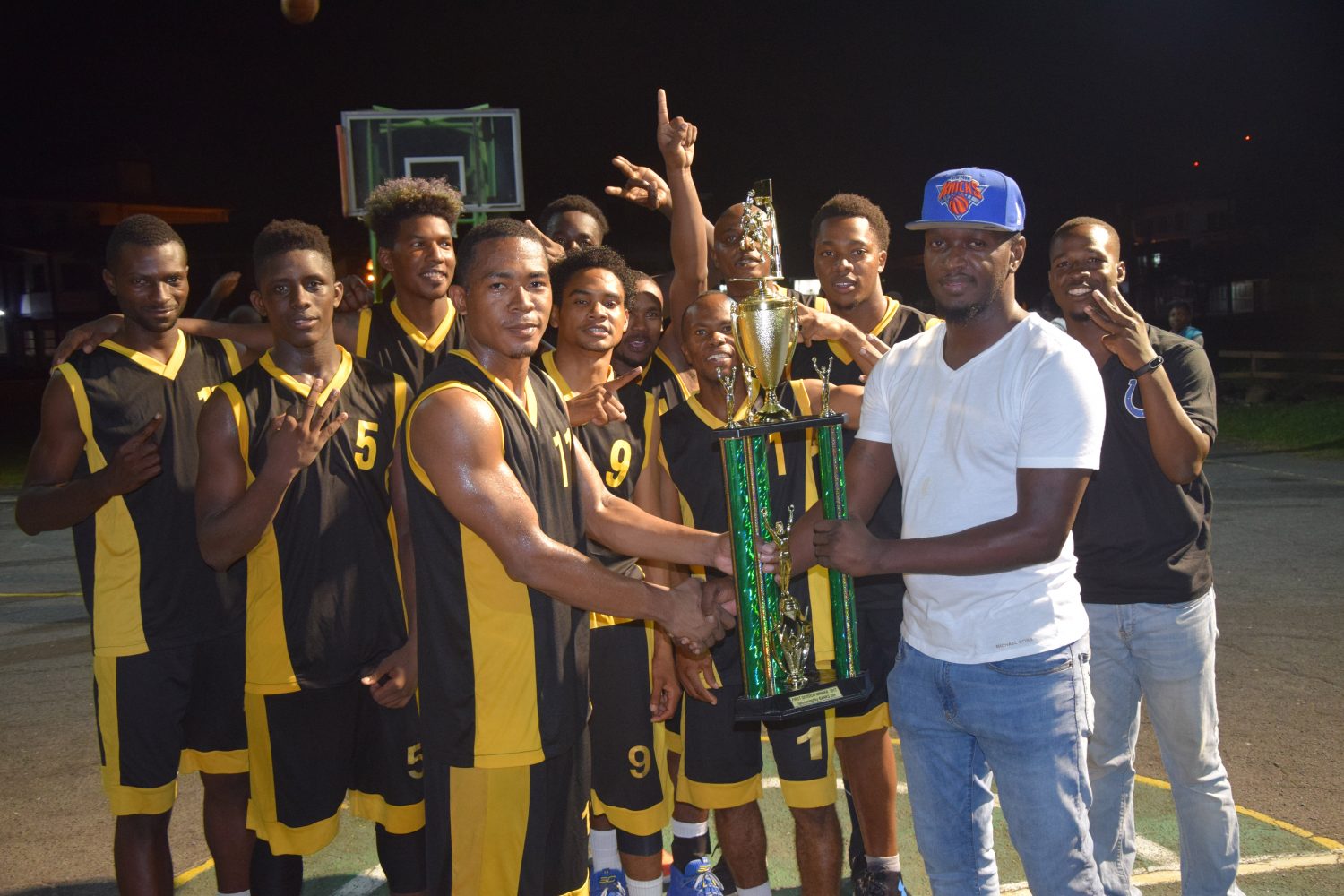 Colts 1st Division Captain Shelroy Thomas collects the championship trophy from GABA Public Relations Officer Rawle Toney, after Colts defeated Plaisance Guardians, to clinch the three match series 2-1 at the Burnham Court on Wednesday