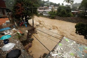 People look at a street collapsed by the Tiribi river flooded by heavy rains from Tropical Storm Nate in San Jose, Costa Rica October 5, 2017
