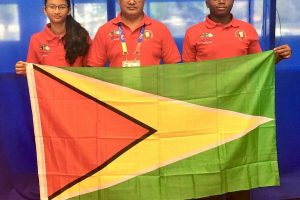 Priyanna Ramdhani, Gokarn Ramdhani and Tyrese Jeffrey display the Guyana flag proudly at the games.
