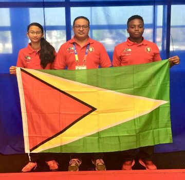 Priyanna Ramdhani, Gokarn Ramdhani and Tyrese Jeffrey display the Guyana flag proudly at the games.