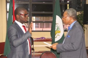 Newly elected student body President Norwell Hinds (left) taking his Oath of Office which is being administered by Vice Chancellor Professor Ivelaw Griffith.
