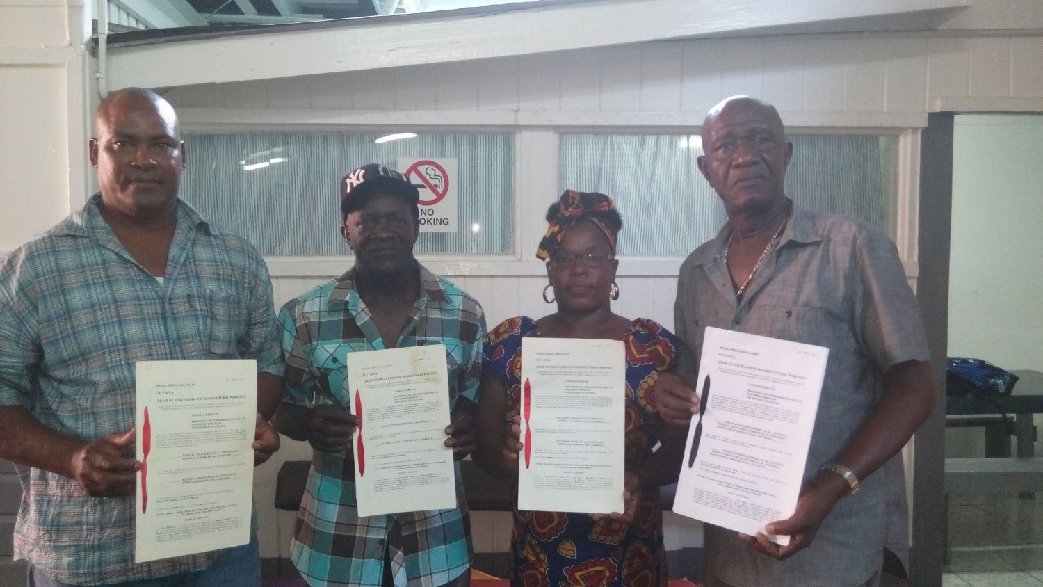 Revoked leases: Rice farmers (from left) Rawle Miller, Rupert Blackman, Doreen Monah and Philip Alexander Johnson holding up their leases earlier this month.
