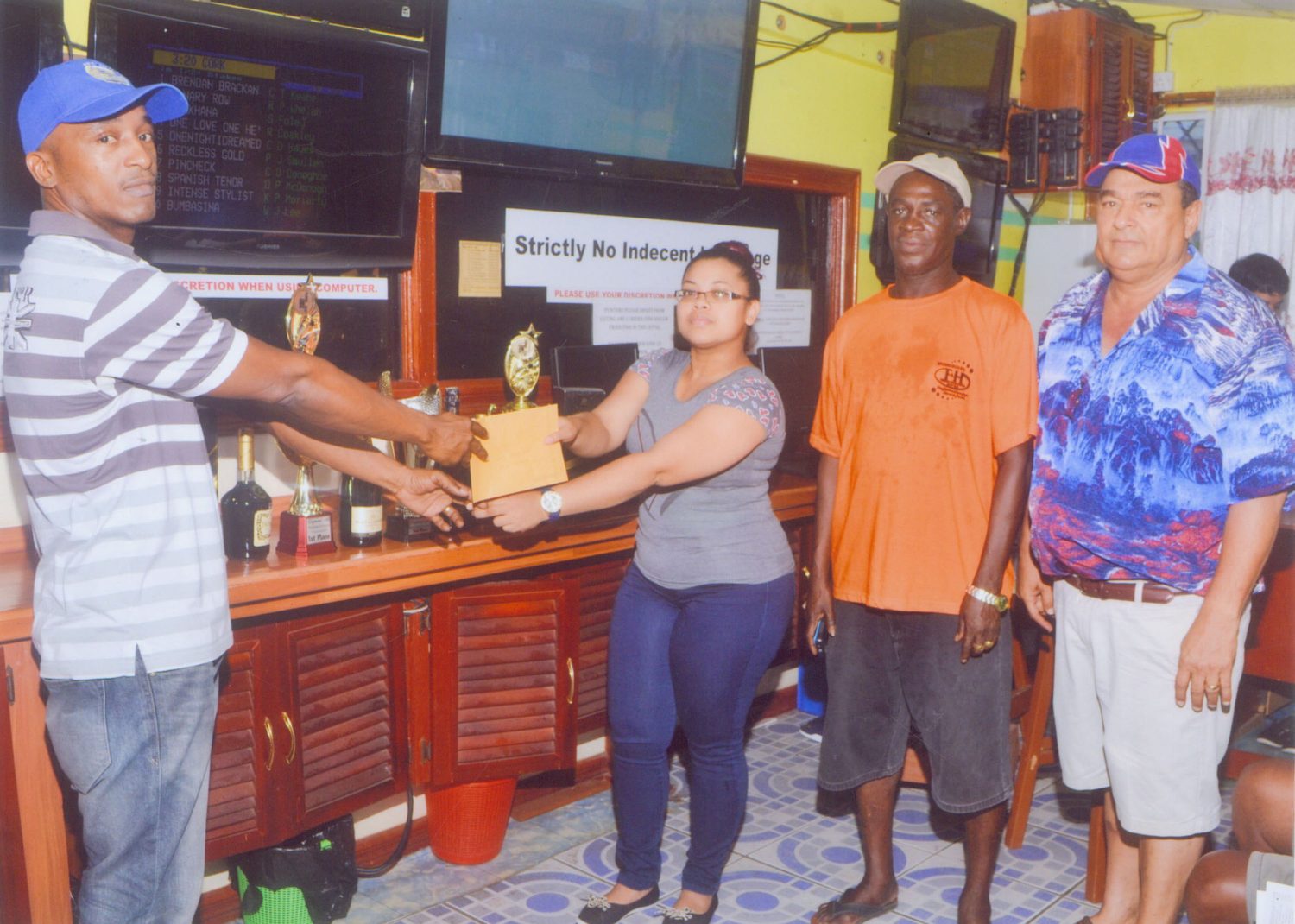 Chief Steward Kevin Boston receives the trophies from Tiffany Solomon, Office Manager of All Seasons.  At right is All Seasons proprietor Raymond Alli and next to him Mark Wiltshire.