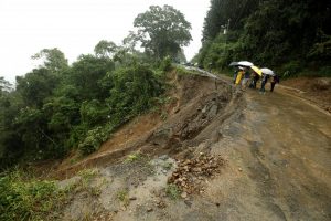 Residents look at a road partially collapsed by heavy rains of Tropical Storm Nate that affects the country in El Llano de Alajuelita, Costa Rica October 5, 2017. REUTERS/Juan Carlos Ulate