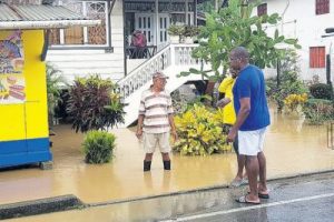Moruga/Tableland MP Dr Lovell Francis chats with two of his constituents whose yard was flooded following heavy overnight rains into yesterday.