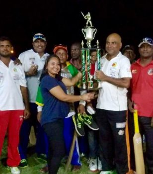 A smiling Floodlights Masters Skipper Ricky Deonarine receives the winning trophy from a representative of Permaul Trading.