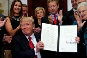 President Trump smiles after signing an Executive Order to make it easier for Americans to buy bare-bone health insurance plans and circumvent Obamacare. (Reuters photo)