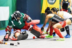 Guyana’s goalkeeper Alysa Xavier (left) pulls off a smart save to deny Trinidad and Tobago’s Kristin Thompson (centre) while team-mate Marisha Fernandes looks on during their fifth place playoff in the Pan American Indoor Hockey Cup at the Cliff Anderson Sports Hall yesterday.

