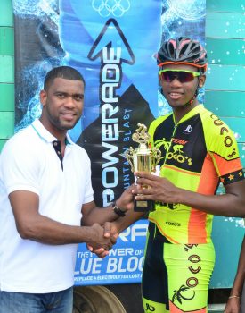 Team Coco’s Jamal John receiving his first place trophy from Errol Nelson, Brand Manager of Banks DIH Limited yesterday following the PowerAde 40-mile road race at West Demerara. (Orlando Charles photo)
