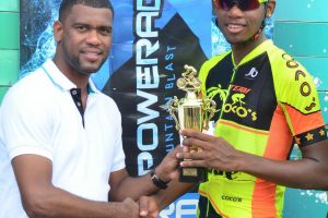Team Coco’s Jamal John receiving his first place trophy from Errol Nelson, Brand Manager of Banks DIH Limited yesterday following the PowerAde 40-mile road race at West Demerara. (Orlando Charles photo)
